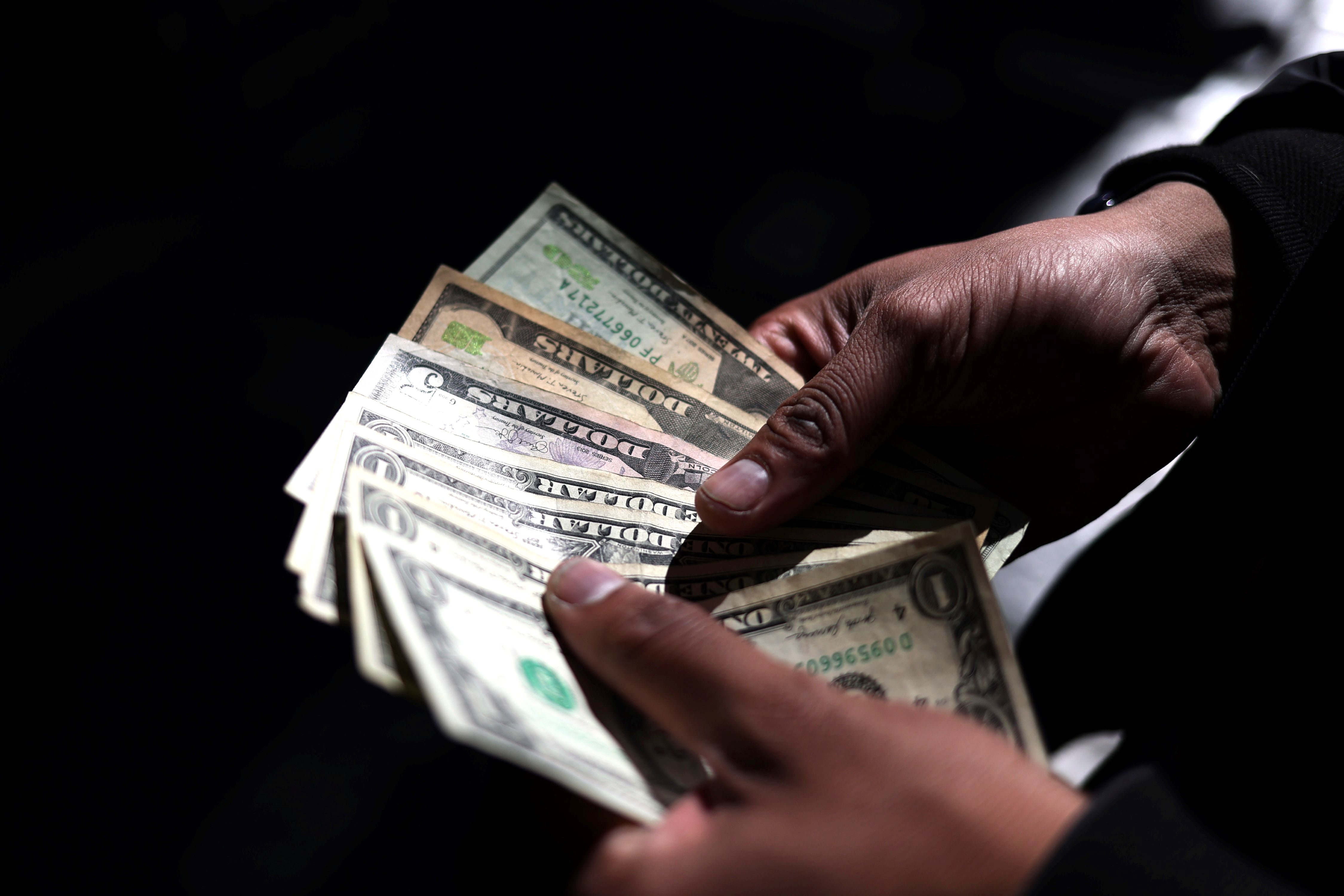 Una persona cuenta dólares, en La Paz (Bolivia). Para algunos expertos, la falta de dólares y combustibles, un bajo crecimiento y una inflación acumulada de 16,92 % son síntomas de una crisis por el agotamiento del modelo defendido por el presidente Luis Arce.