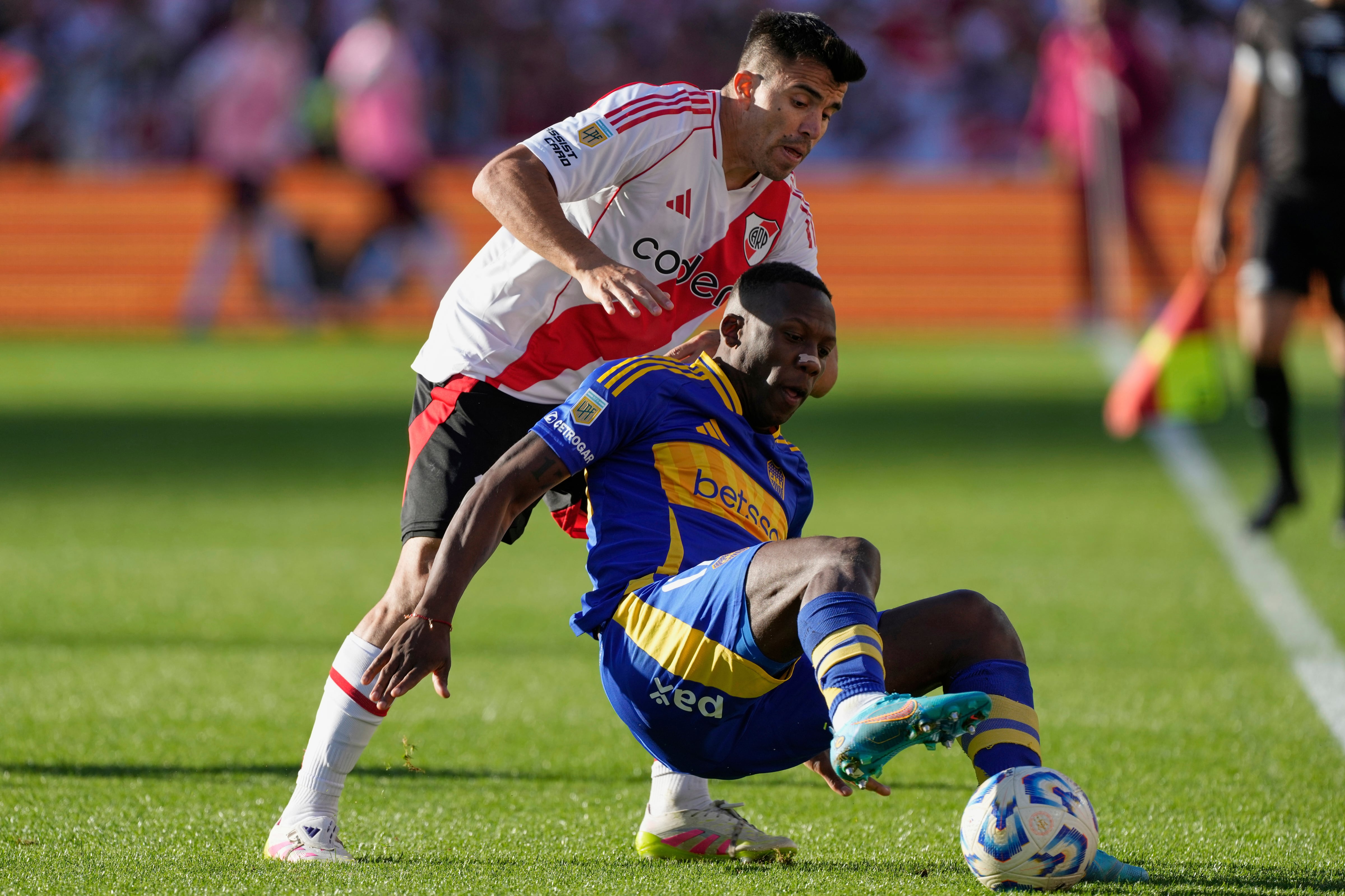 Luis Advíncula, de Boca Juniors, protege la pelota de Marcos Acuña de River Plate durante un partido del torneo local en Buenos Aires, Argentina, el domingo 27 de abril de 2025. (AP Photo/Gustavo Garello)