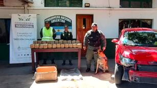 Efectivos de Gendarmería Nacional posan junto a los 50 kilos de marihuana encontrados por el can "Bailey", en Jujuy.