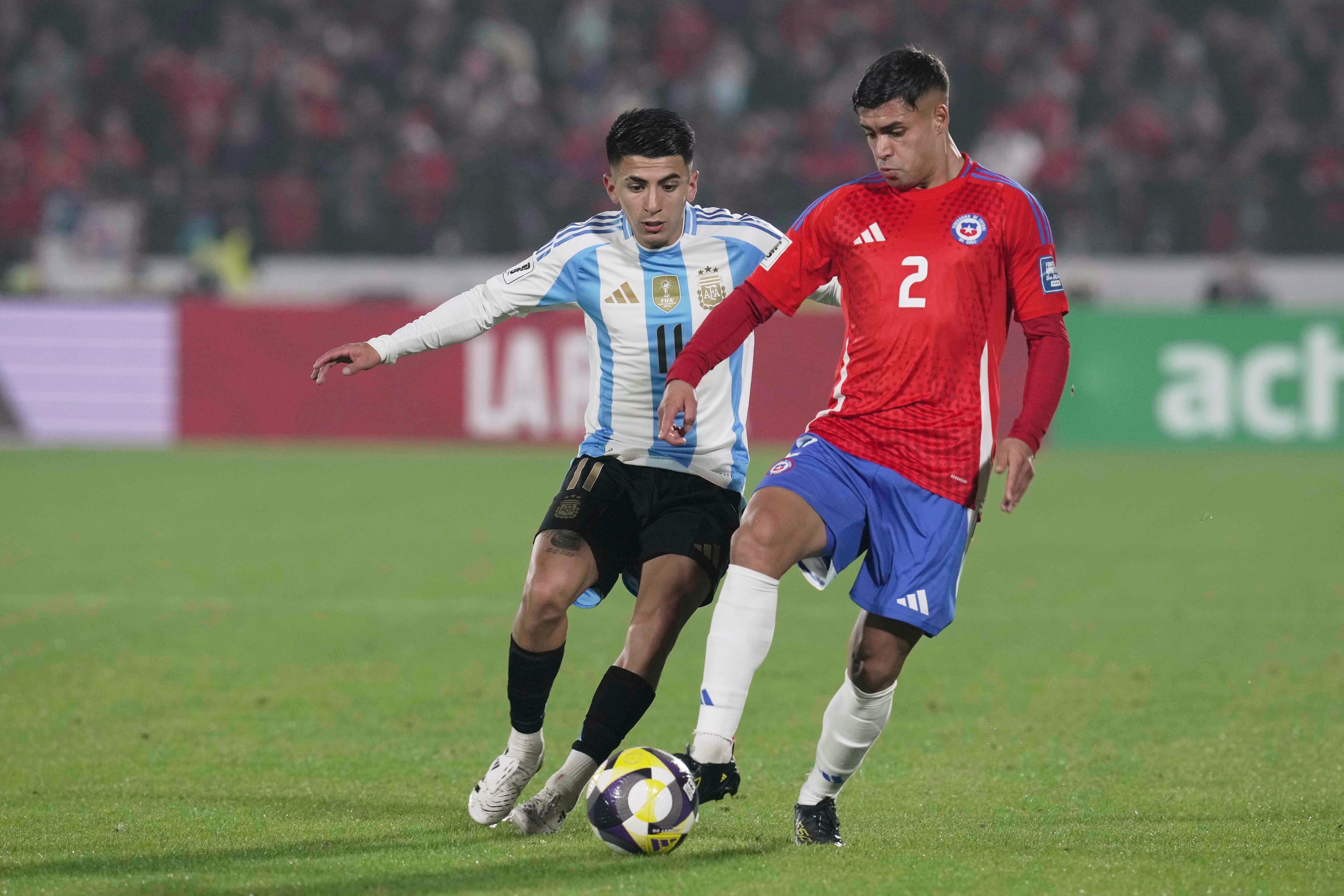 El chileno Fabian Hormazabal pelea por el balón con el argentino Thiago Almada en el encuentro de la eliminatoria mundialista el jueves 5 de junio del 2025. (AP Foto/Luis Hidalgo)