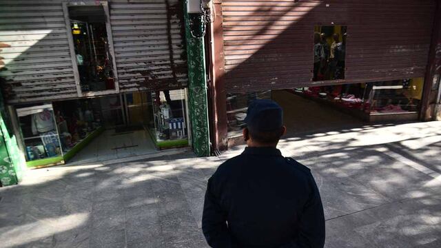 Inspectores municipales y policía hacen bajar las percianas a comerciantes del área peatonal en la ciudad de Córdoba. (Pedro Castillo/ La Voz)