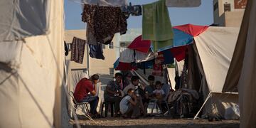 Palestinos desplazados por los ataques israelíes contra la Franja de Gaza sentados en un campamento del Programa de las Naciones Unidas para el Desarrollo en Jan Yunis, el 19 de octubre de 2023. (AP Foto/Fatima Shbair)