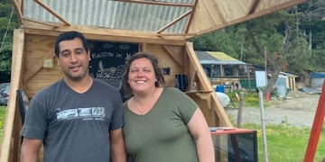 Andrés junto a su esposa Mariana. De fondo se puede ver su emprendimiento, un puesto de panificados, que lleva el nombre de su hijo.