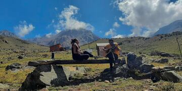 Irina cantando con postales de montañas de Mendoza.