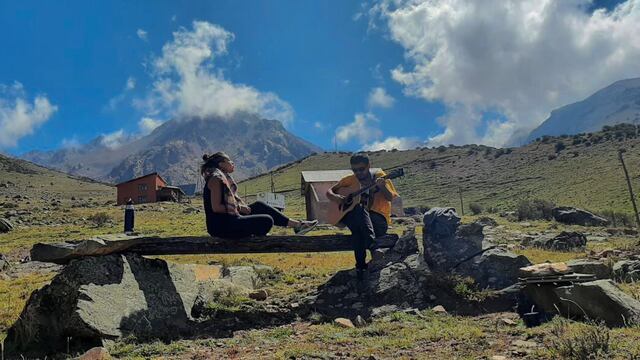 Irina cantando con postales de montañas de Mendoza.