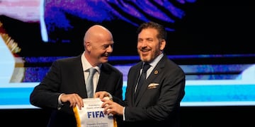 El presidente de la FIFA Gianni Infantino (izquierda) entrega un banderín al líder de la CONMEBOL Alejandro Domínguez el viernes 31 de marzo de 2023 en Luque, Paraguay (AP Foto/Jorge Saenz)