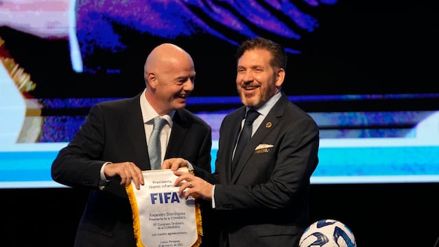 El presidente de la FIFA Gianni Infantino (izquierda) entrega un banderín al líder de la CONMEBOL Alejandro Domínguez el viernes 31 de marzo de 2023 en Luque, Paraguay (AP Foto/Jorge Saenz)