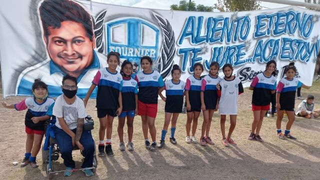 Pablo Ochoa junto a uno de los equipos femeninos y detrás la bandera que le hizo a su hermano Diego quien falleció de coronavirus.