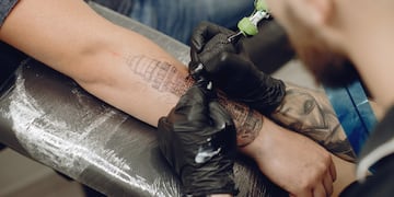 Tatuador realizando un tatuaje