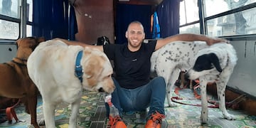 León Sipes junto a sus amigos caninos en su colectivo.