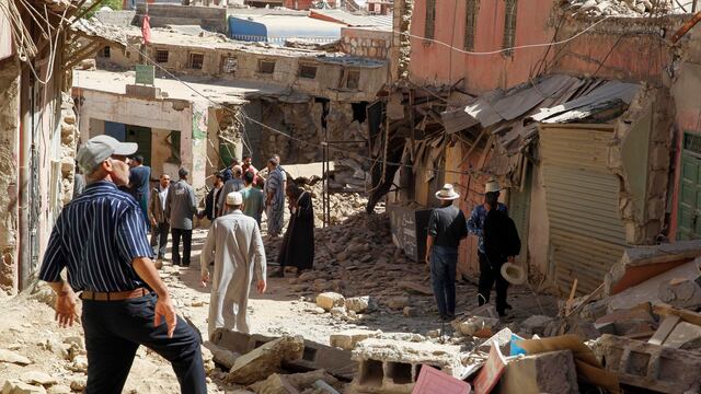 Varios hombres caminan por las calles de Amizmiz, situada a unos 30 kilómetros del epicentro del terremoto, en las faldas del Atlas, que amaneció este sábado llena de cascotes y escombros de edificios derruidos tras el terremoto que sacudió el suroeste del país la pasada madrugada.