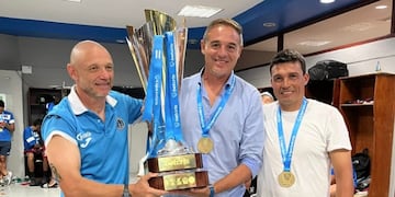 El profe Juan Bertani (izquierda) junto a la "Tota" Medina levantando el nuevo trofeo ganado en Honduras.