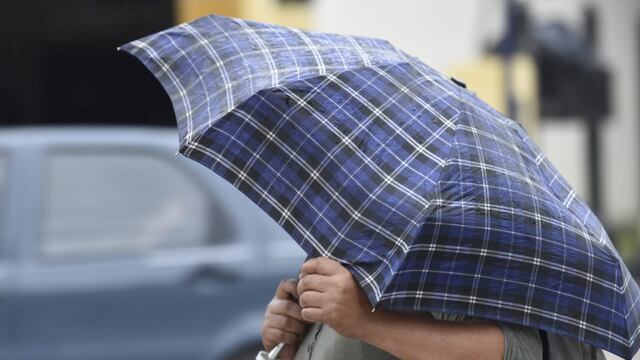Los cordobeses se cubren de la lluvia.