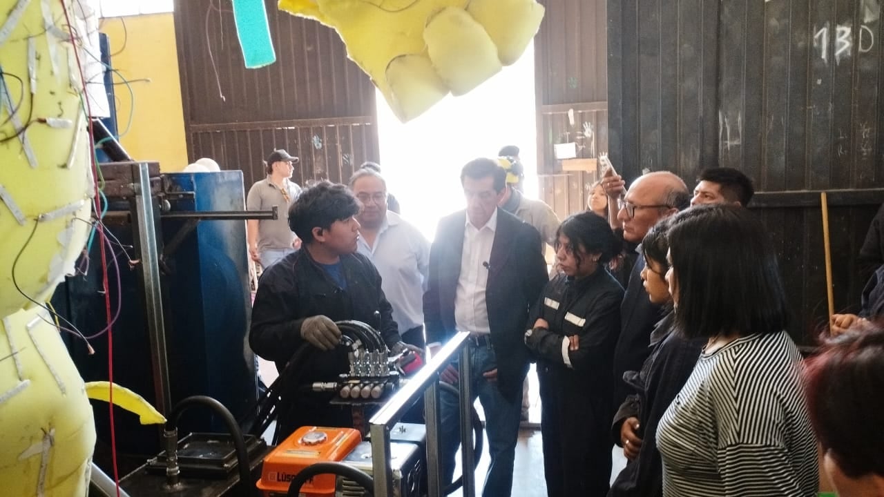 Uno de los carroceros encargados del circuito hidráulico que moverá los elementos de la carroza, explica al gobernador Sadir el funcionamiento del sistema.