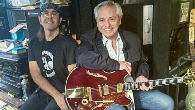Alberto Fernández probando una guitarra junto a un músico de David Bowie