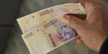 Iguales, pero distintos. Los dos billetes son verdaderos, pero uno tiene el número 100 y el otro carece de esa inscripción. Errores surgidos al calor de la impresión de pesos (Martín Baez/La Voz).