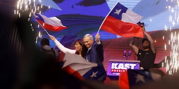 El presidente electo de Chile, José Antonio Kast, y su esposa, María Pía Adriasola, agitan banderas de su país este domingo, en la capital Santiago. Kast dijo que sus prioridades van a ser "seguridad, inmigración y progreso económico" y aseguró que "Chile necesita orden en las calles y en el Estado".