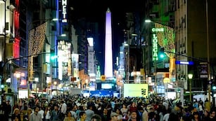 La calle Corrientes en el microcentro porteño repleta de gente consumiendo en bares, restaurantes, cines y teatros.