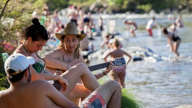 Sol y río. Con la guitarra, junto al agua, turistas disfrutan ayer en el balneario Mate de Luna, de Santa Rosa de Calamuchita (LaVoz).