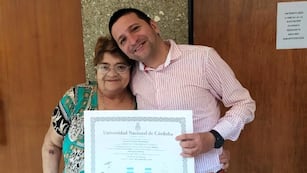 Sebastián con su madre, y con el título de la UNC recién obtenido en la mano.