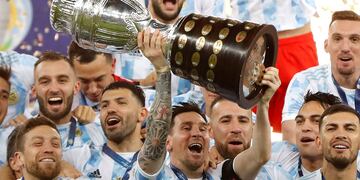 Argentina's Lionel Messi holds the trophy as he celebrates with the team after beating 1-0 Brazil in the Copa America final soccer match at the Maracana stadium in Rio de Janeiro, Brazil, Saturday, July 10, 2021.