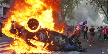 Quema de un patrullero durante la manifestación. (AP)