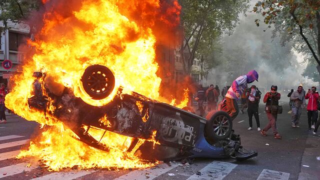 Quema de un patrullero durante la manifestación. (AP)