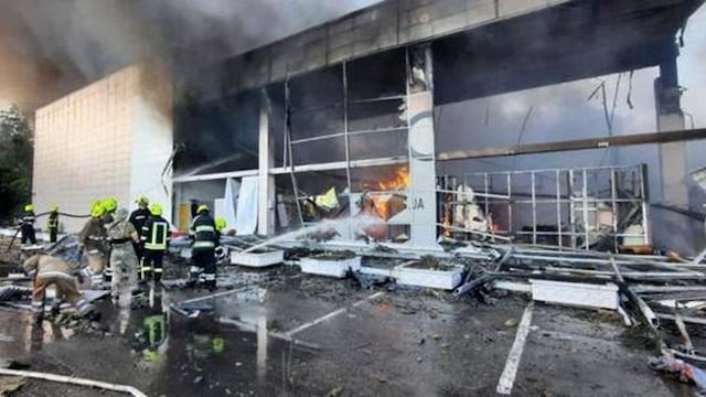 Los bomberos intentando apagar las llamas tras el ataque al centro comercial de Kremenchuk.