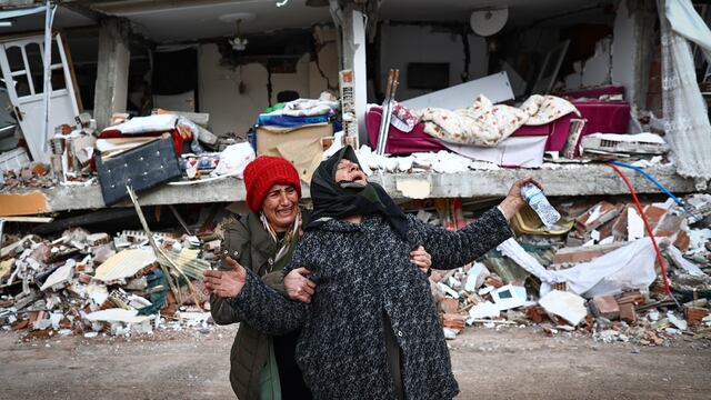 Mujeres reaccionan en el lugar de un edificio derrumbado tras un gran terremoto en el distrito de Elbistan de Kahramanmaras, Turquía (EFE)