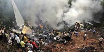ARCHIVO - Civiles observan a bomberos y rescatistas trabajar en el lugar donde se estrelló un avión de Air India en Mangalore, en el estado de Karnataka, en el sur de India, el sábado 22 de mayo de 2010. (AP Foto, archivo)