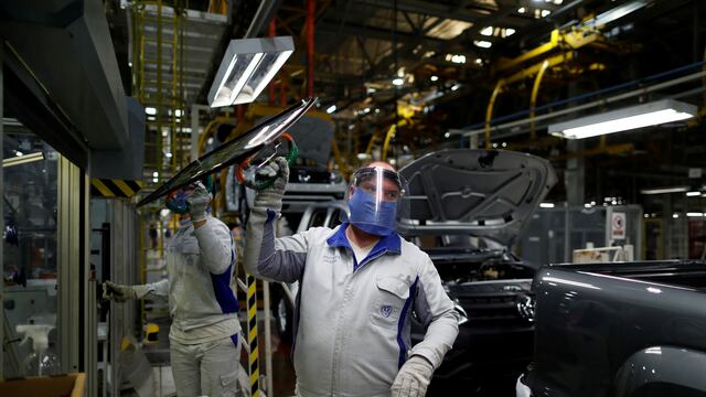 Ensambladores de Volkswagen trabajan en un modelo Amarok con equipo de protección. (Foto: REUTERS / Agustin Marcarian)