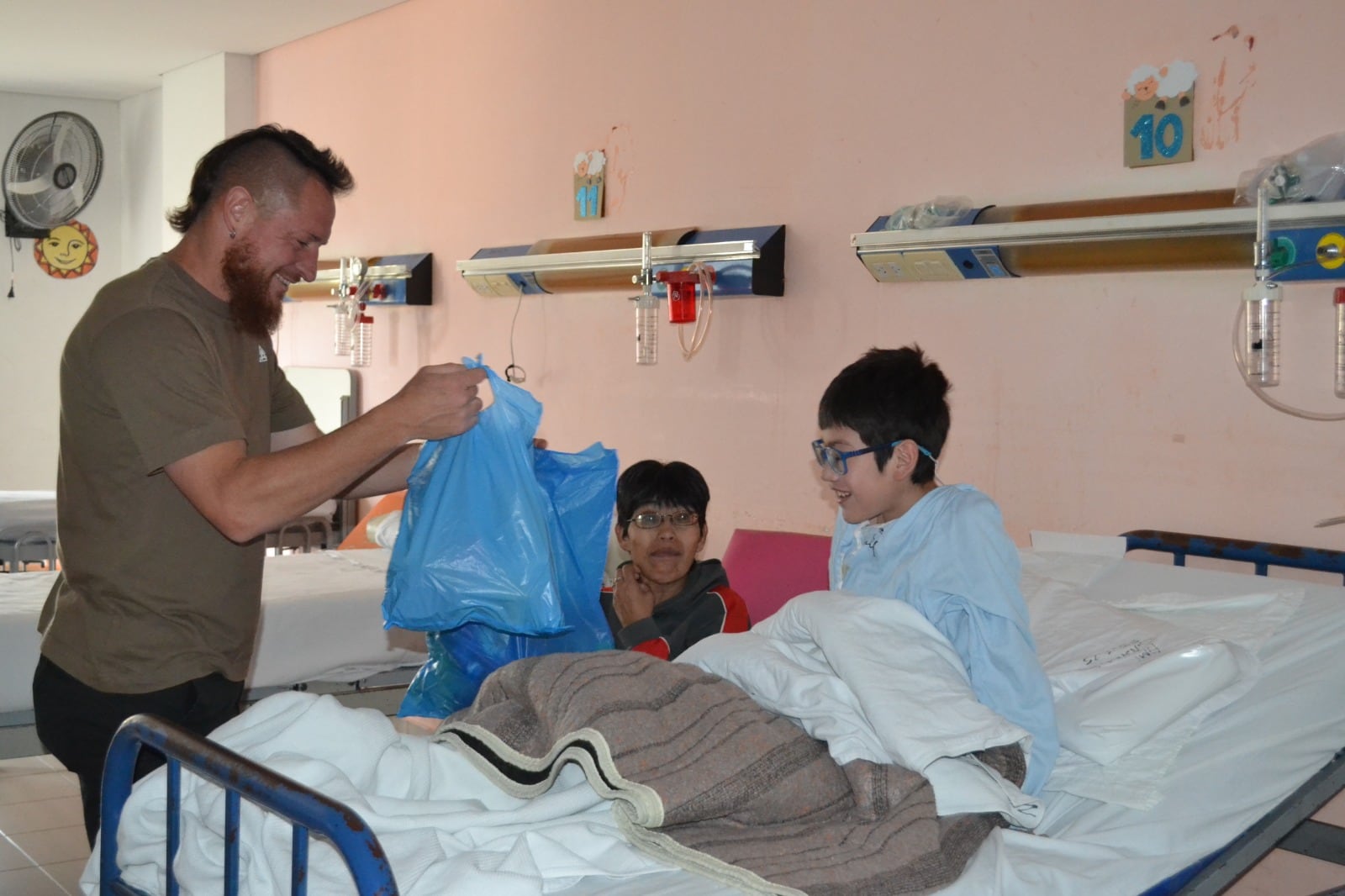 El "Vikingo" Nicolás Dematei entregando obsequios a uno de los niños que es atendido en el Hospital Materno Infantil de Jujuy.