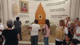 Peregrinos frente al altar en honor a Acutis en el templo de La Falda.
