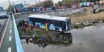 Tras la colisión, el colectivo de Tamse cayó al vacío y, por poco, no terminó en el cauce del Suquía. (Policía)