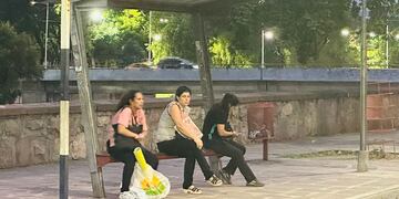 Usuarias del transporte público de pasajeros aguardan el paso de los colectivos, en San salvador de Jujuy.