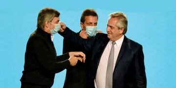 El presidente Fernández saludando a Máximo Kirchner frente a Sergio Massa