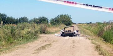 Auto prendido fuego en el que se trasladaban las víctimas del triple crimen de Ibarlucea. (Télam)