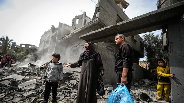 Palestinos recopilan sus pertenencias entre los escombros de un edificio residencial tras un ataque aéreo israelí en el campo de refugiados de Maghazi, en el centro de la Franja de Gaza, el 29 de marzo de 2024.