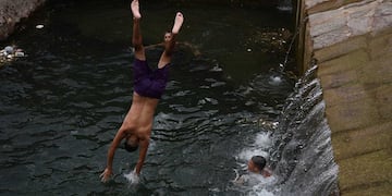 Ola de Calor. Altas temperaturas se registran en la provincia.
Un grupo de jóvenes se refresca en el canal Cacique Guaymallén frente al estadio de Godoy Cruz Antonio Tomba