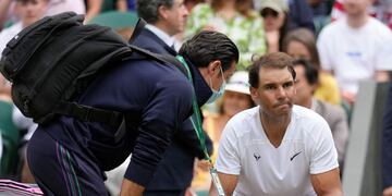 "Rafa" recibe asistencia en el banco. Con fisio y antiinflamatorios logró relajar la zona para terminar su partido de cuartos de final en Wimbledon.