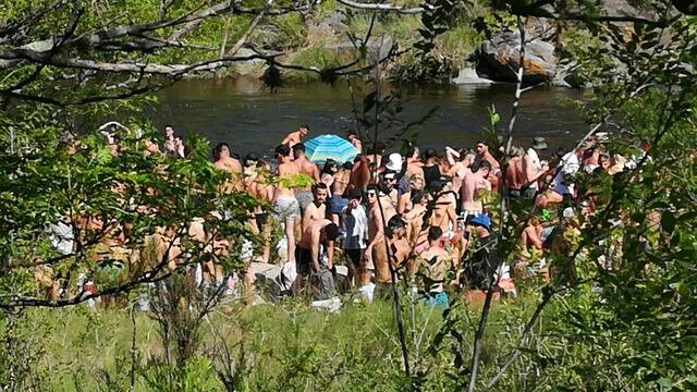 Aglomeración de jóvenes en las costas del río San Antonio.