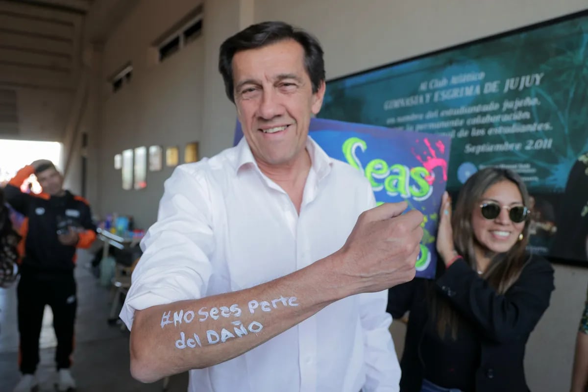 Un simpático gesto tuvo el gobernador Sadir accediendo a llevar en su brazo la consigna "No seas parte del daño", en la fiesta realizada en el estadio "23 de Agosto".