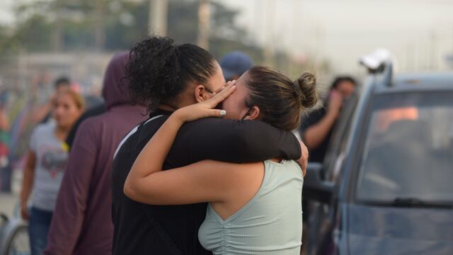 Familiares de presos lloran y se abrazan mientras esperan información a las afueras de la penitenciaría. EFE/ Marcos Pin.