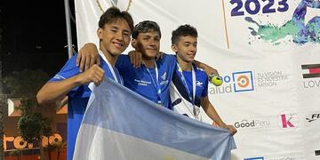 Mauro Czybuk (primero en la foto) con la bandera Argentina, en el Torneo de las Américas XXX Copa Regatas disputado en Lima, Perú.