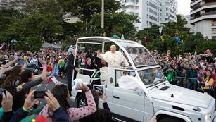El papa Francisco saluda a la multitud desde su papamóvil frente a la playa de Copacabana, a su llegada para la procesión de las estaciones del vía crucis, el viernes 26 de julio de 2013, en Río de Janeiro. (AP Foto/Andre Penner, archivo)