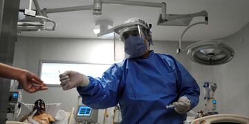 Trabajadores de la salud atienden a un paciente con covid-19 en la unidad de cuidados intensivos del Hospital Central de Mendoza. (Foto: Andres Larrovere / AFP)