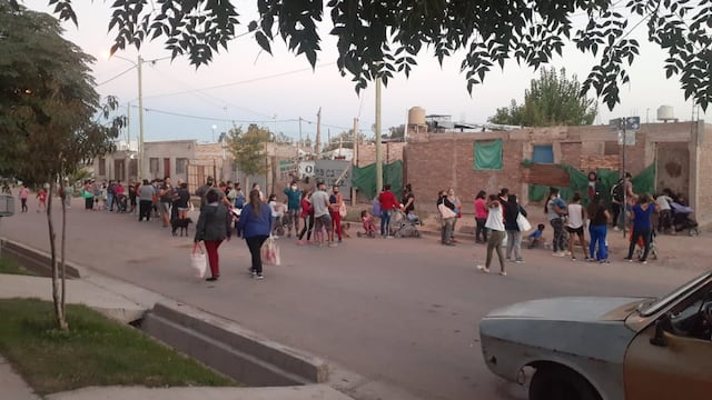 Familias haciendo fila en la puerta del comedor para ingresar a comer.