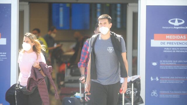 Pasajeros del último vuelo autorizado procedente del Reino Unido arriban al aeropuerto internacional de Ezeiza. (Clarín)