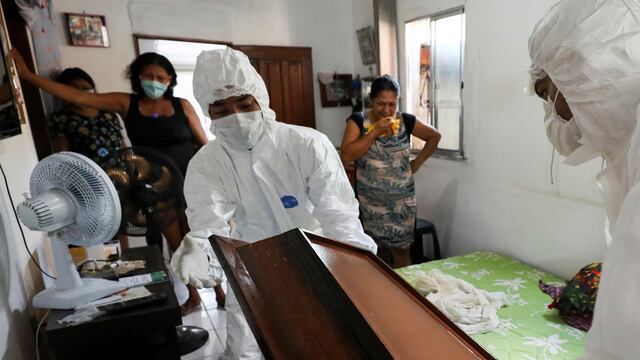 Personal con la indumentaria correspondiente prepara el cajón de una víctima de coronavirus en Manaos Foto: REUTERS/Bruno Kelly