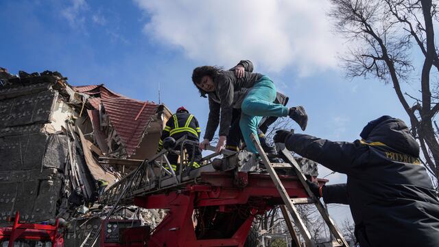 Bomberos rescatan a una mujer atrapada en un edificio residencial de la ciudad de Mariúpol. Foto: AP Photo/Evgeniy Maloletka.